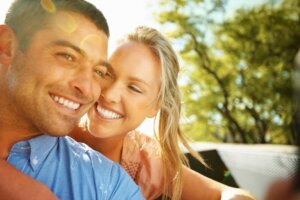 Closeup of happy woman embracing boyfriend outdoors