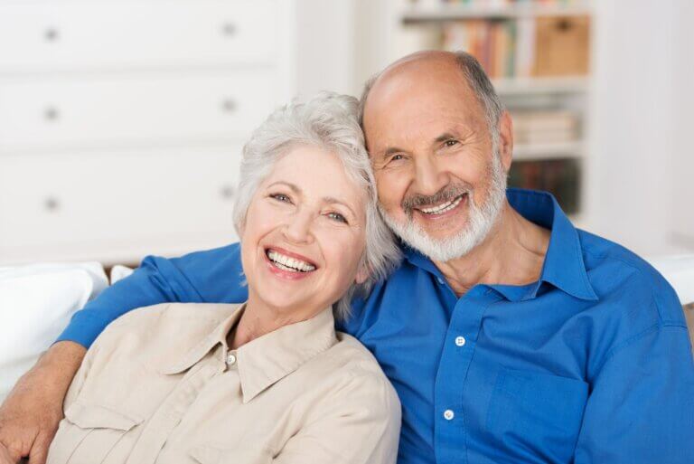 Mature Couple Leaning On Each Other While Sitting On Couch