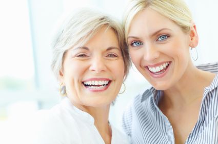 Mature Female With Middle Aged Female Smiling Together after having ceramic dental implant procedure
